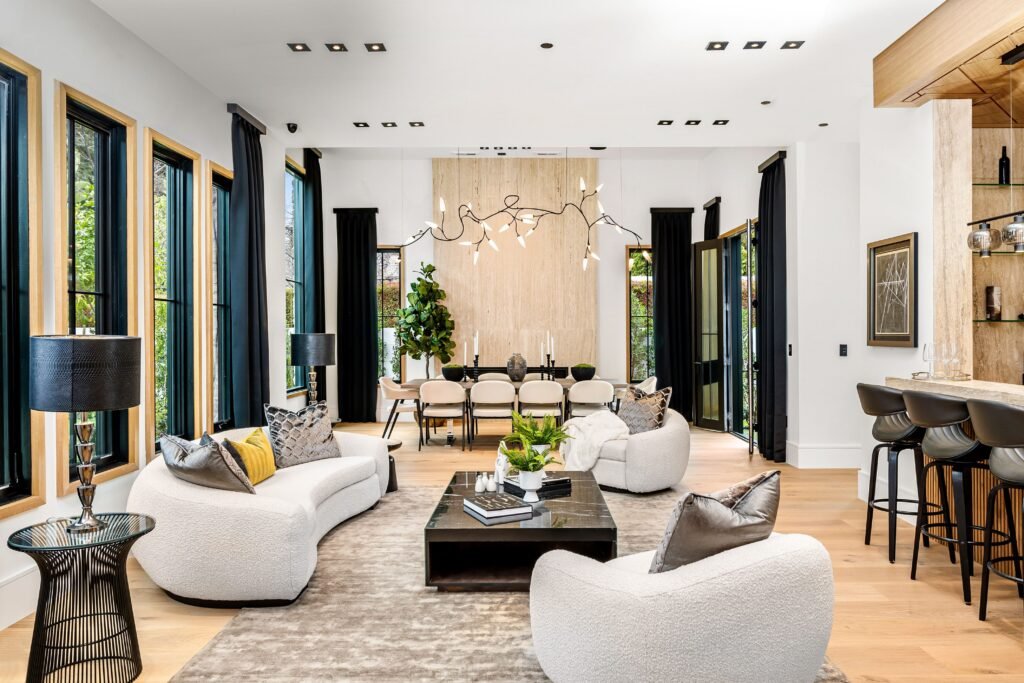 Modern living room with stylish furniture and large windows.